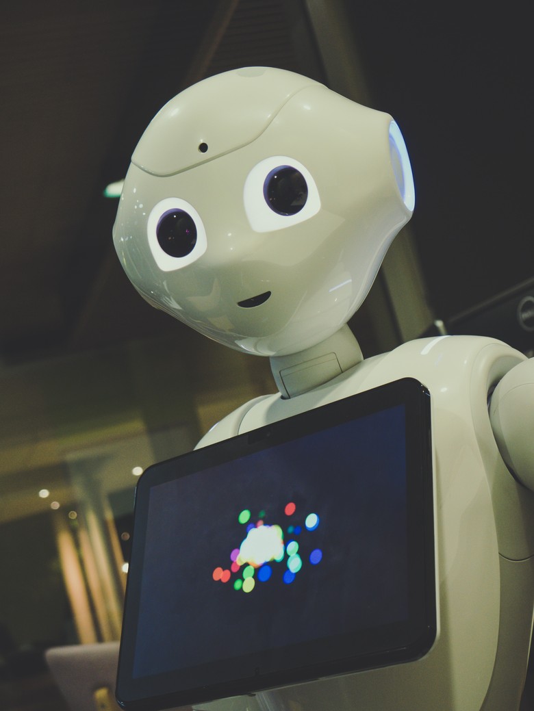 Zu erkennen ist ein Roboter, der einen Touchscreen vor sich trägt.
