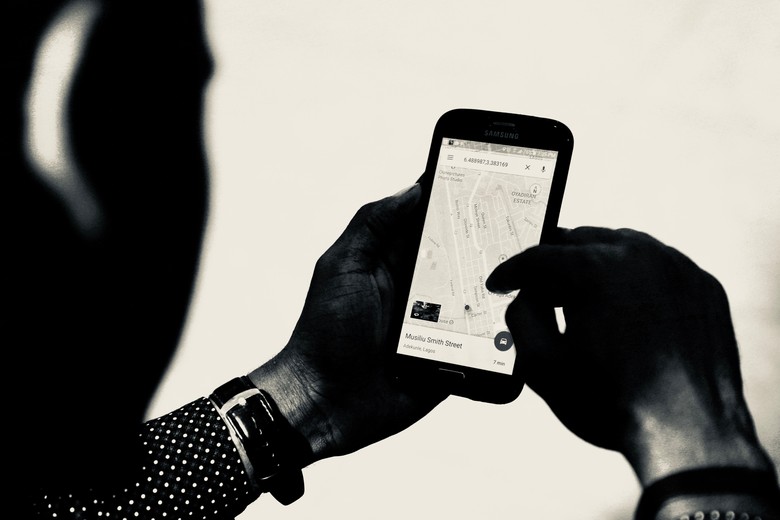 Eine Person hält ein Smartphone in der Hand, auf dem eine Stadtkarte geöffnet ist.