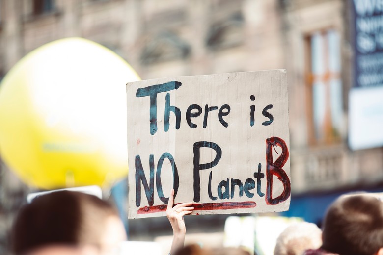 Ein Plakat mit der Aufschrift: "There is no Planet B" wird in die Höhe gehalten.