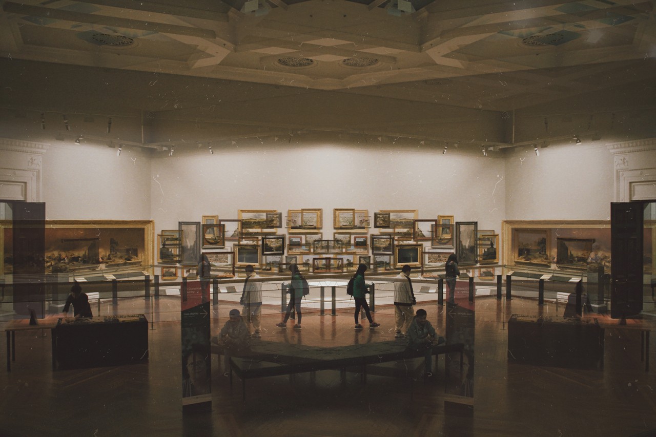 Schemenhafte Menschen erkunden einen Museumsraum.